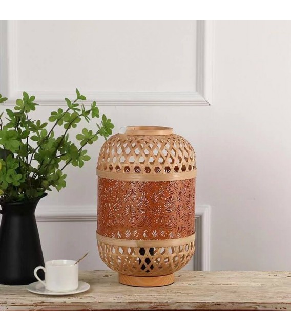 Lámpara oriental en bambú y metal, luz cálida con diseño artesanal.