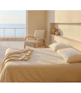 Butaca nórdica con estructura de madera y tapizado en chenilla beige.